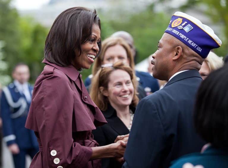 La foto muestra a Michelle Obama conversando con la gente.